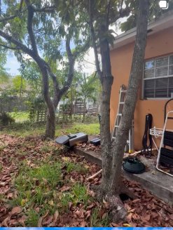 Overgrown backyard and orange stucco house during a Prop Hunters renovation